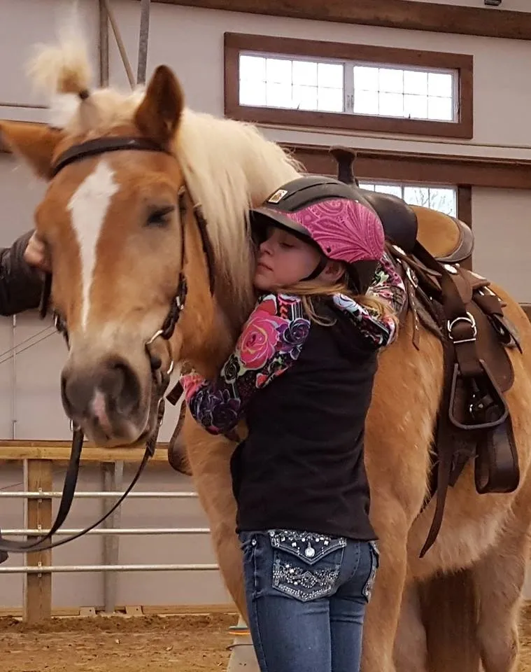 Girl hugging horse