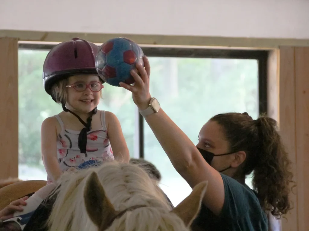 Caroline Lurie helps Sophia with her hippotherapy OT session