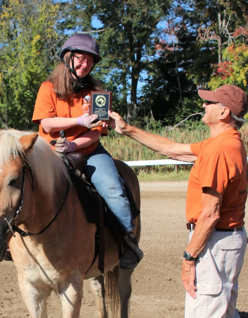 Jenny Landers (right) receives the Spirit Award from Nick DeNitto (left) in 2019